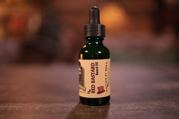 1oz bottle of red bastard beard oil green bottle dropper top